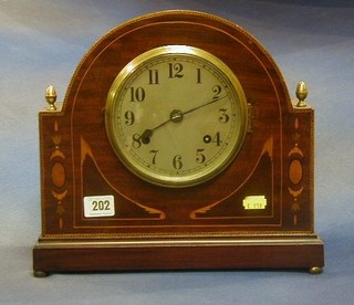 An Edwardian 8 day striking mantel clock contained in an arched shaped inlaid mahogany case, the silvered dial with Arabic numerals