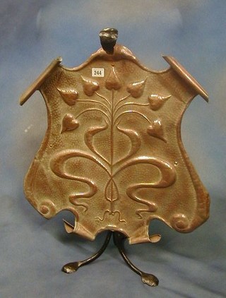 An Art Nouveau embossed copper and wrought iron fire screen of shield shape embossed flower heads 28"