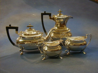 A 4 piece Georgian style silver tea service raised on 4 trifid supports comprising teapot, twin handled sugar bowl and hotwater jug, Sheffield 1924, 64 ozs