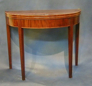 A Georgian mahogany demi-lune shaped tea table inlaid satinwood stringing and raised on square reeded chamfered supports 36"