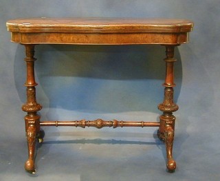 A Victorian figured walnutwood card table of serpentine outline, raised on carved bulbous supports with H framed stretcher 37"