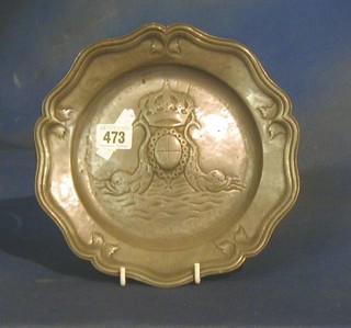 A circular embossed pewter plate with bracketed border and armorial decoration 9"