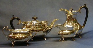 A silver 4 piece tea service comprising teapot, hotwater jug, twin handled sugar basin and cream jug, raised on trifid feet, Birmingham 1929, 65 ozs 