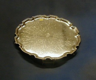 A silver salver with bracketed border raised on 3 scrolled supports Birmingham 1928, inscribed, 16" diam. 61 ozs