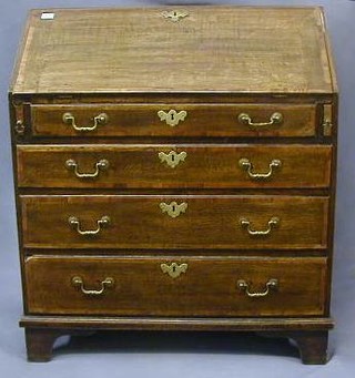 A George III oak bureau with mahogany crossbanding, the fall flap revealing a well fitted interior above 4 long graduated drawers with brass swan neck drop handles and raised on bracket feet 34"