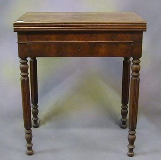 A William IV walnutwood card table fitted a frieze drawer and raised on  turned and reeded supports 25"