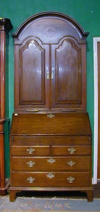 A fine quality 18th Century oak bureau bookcase with domed top the interior fitted adjustable shelves enclosed by arched panelled doors, the base with 2 brushing slides the fall front revealing a well fitted stepped interior above 2 short drawers, raised on bracket feet 37" 