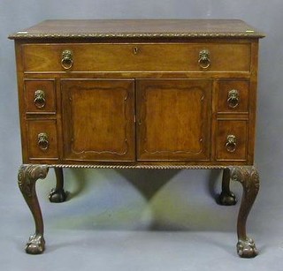 A George III mahogany wash stand fitted a deep drawer with mirror above  cupboard enclosed by panelled doors flanked by 4 drawers and 1 long drawer, raised on cabriole ball and claw supports 33" 