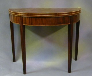 A Georgian mahogany demi-lune shaped tea table inlaid satinwood stringing and raised on square reeded chamfered supports 36"