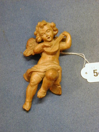 A carved lime wood figure of a cherub playing a mandolin