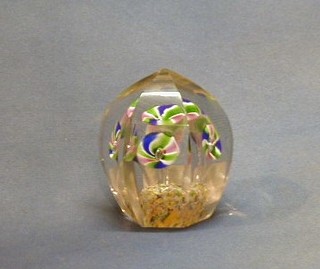 A modern glass paperweight in the form of a dome, the centre with floral decoration