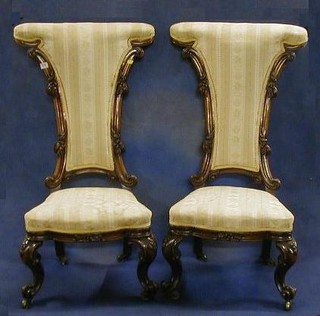 A pair of Victorian carved walnutwood show frame Pri-Dieu chairs raised on cabriole supports   