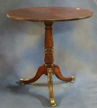 A Georgian mahogany snap top tea table with crossbanded top raised on a gun barrel column with pillar and tripod supports ending in brass caps and castors 30"   