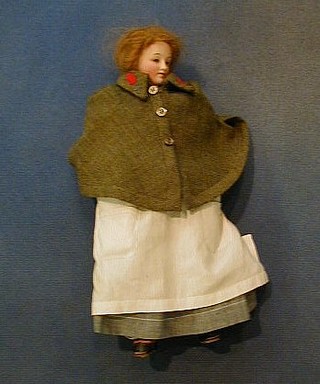 A 19th/20th Century porcelain headed doll in a nurses uniform