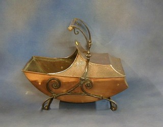 An Art Nouveu embossed copper boat shaped coal scuttle raised on iron supports  