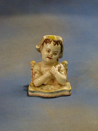 A faience egg cup/vase in the form of a head and shoulders bust of a seated child with doll and a high chair 5"