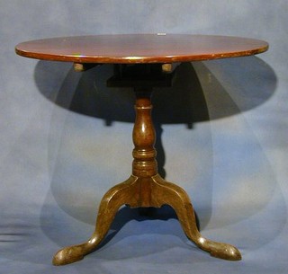 A Georgian mahogany circular snap top tea table with bird cage action, raised on gun barrel and tripod supports 13"