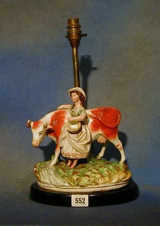 An 18th Century Staffordshire figure of a standing cow with milkmaid, (sympathetically converted for use as a table lamp) 8" (handles to milk pail f)