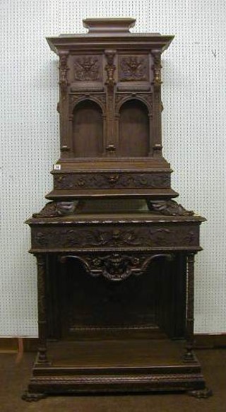 A 19th Century Italian walnutwood cabinet on stand, the upper section fitted 2 drawers above 2 niches, the stand fitted a drawer and raised on 2 columns with undertier, carved grotesque figures throughout, 35"