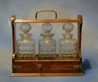 A late Victorian oak tantalus complete with 3 cut glass bottles