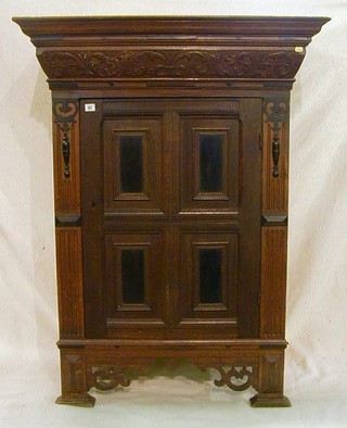 A 17th Century carved oak Dutch cabinet with moulded cornice above a carved frieze, enclosed by a panelled door, raised on square supports 39"