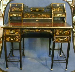 A fine quality 19th Century aesthetic movement black lacquered writing table, the pierced raised back fitted a stationery box flanked by a pair of cupboards with inset tooled leather writing surface above 2 short drawers, raised on square tapering supports 42"