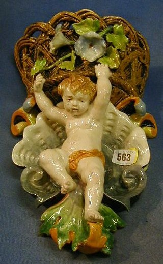 A Majolica wall pocket in the form of a basket supported by a cherub 14"