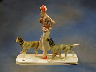 An Art Deco Continental porcelain figure of a lady with 2 dogs, the base impressed 27, raised on a walnutwood base 13"