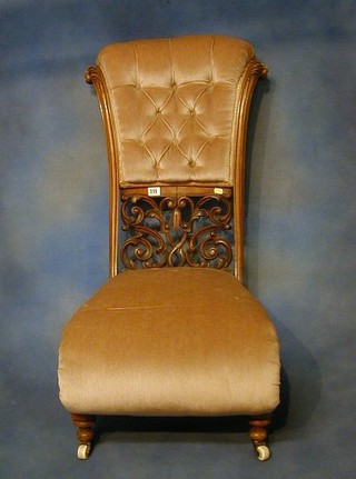 A fine quality Victorian pierced and carved walnutwood scroll back nursing chair upholstered mustard coloured Dralon, on turned supports with ceramic castors (slight worm)