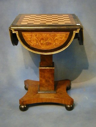 A William IV figured walnutwood drop flap pedestal games table inlaid a chessboard and raised on a chamfered column and triform base 20"