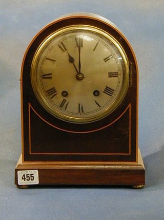 An Edwardian 8 day striking bracket clock with silver dial and Roman numerals contained in an arched inlaid mahogany case