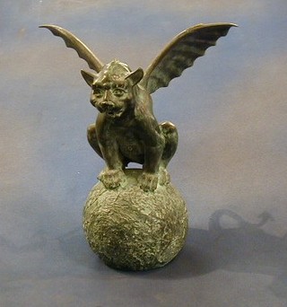 A bronze figure of a winged mythical beast sat on a globe 13"