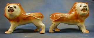 A pair of 19th Century Staffordshire figures of standing lions with glass eyes 10" (1 r)
