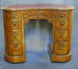 A lady's Victorian mahogany kidney shaped desk with inset tooled leather writing surface, above 1 long and 8 short drawers 39"