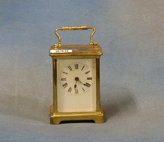 A 19th/20th Century French carriage timepiece with enamelled dial and Roman numerals contained in a gilt metal case