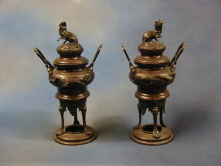 A pair of 19th Century Oriental bronze twin handled Koros, the lids decorated dogs of fo, 12"