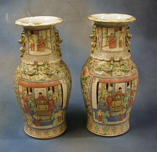 A pair of 19th Century Canton famille rose twin handled porcelain vases with panels decorated court figures 18" (1 f)