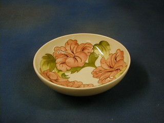 A Moorcroft Hibiscus pattern on a cream ground pottery bowl, the base impressed Moorcroft Made in England 10"