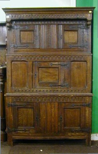 An antique oak Tridarn with moulded cornice and arcaded decoration, the upper section fitted a double cupboard enclosed by panelled doors, the centre section fitted 1 cupboard, the base fitted a double cupboard 42"