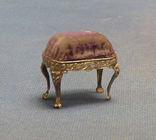 An Edwardian embossed silver pin cushion in the form of a dressing table stool, on cabriole supports Birmingham 1901