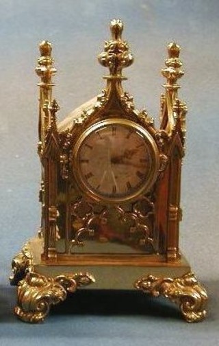 A 19th Century mantel timepiece contained in a gothic gilt brass case