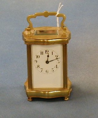A 19th Century French carriage clock with enamelled dial and Arabic numerals contained in a shaped metal case