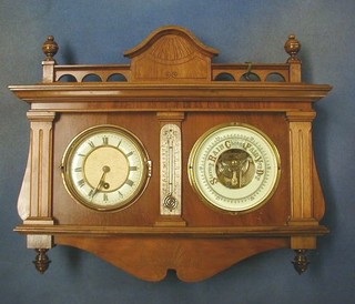 An Edwardian combined thermometer, barometer and clock contained in a carved walnutwood case
