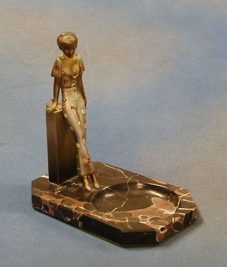 An Art Deco painted spelter table lighter in the form of a standing lady, raised on a black veined marble base incorporating an ashtray 8"