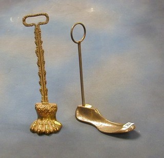 A brass door stop in the form of a lions paw and 1 other