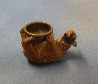 A carved Swiss ashtray in the form of a reclining bear with brass bowl