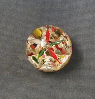 A circular glass paperweight with floral decoration 2"