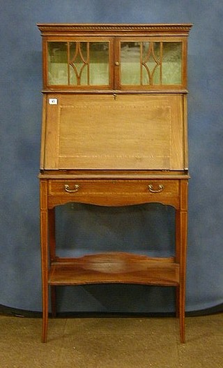 An Edwardian inlaid mahogany student's bureau, the upper section with moulded and dentil cornice fitted a display cabinet enclosed by an astragal glazed panelled door, the fall front revealing a well fitted interior above 1 long drawer raised on square tapering supports with undertier, 26"