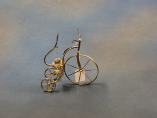 A silver plated brandy warmer in the form of a penny farthing tricycle