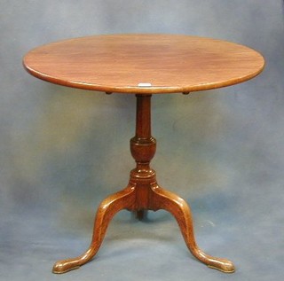 A Georgian mahogany circular snap top tea table raised on pillar and tripod supports 31"